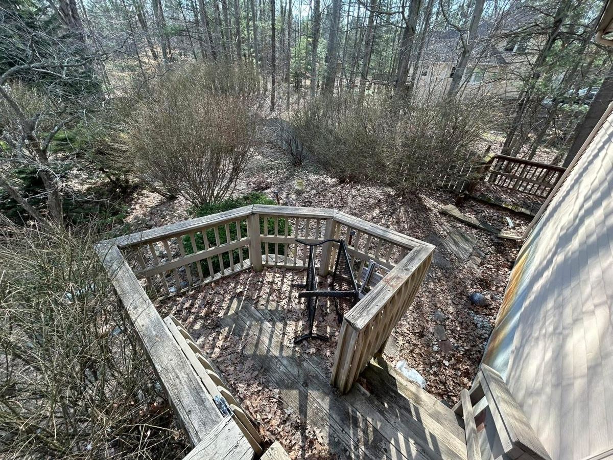 Before — curved deck and retaining wall covered in debris