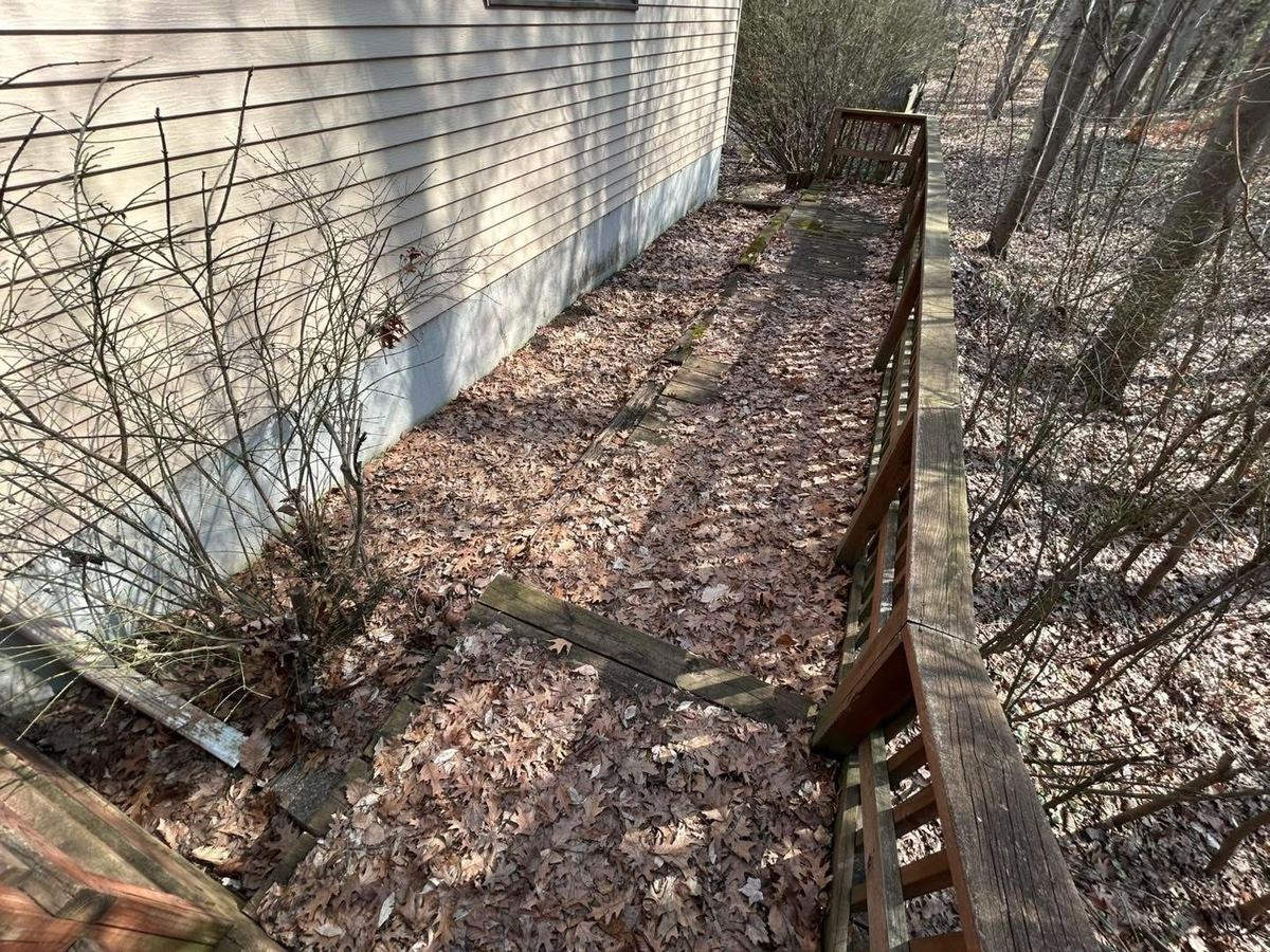 Before — wooden steps and walkway covered in fallen leaves