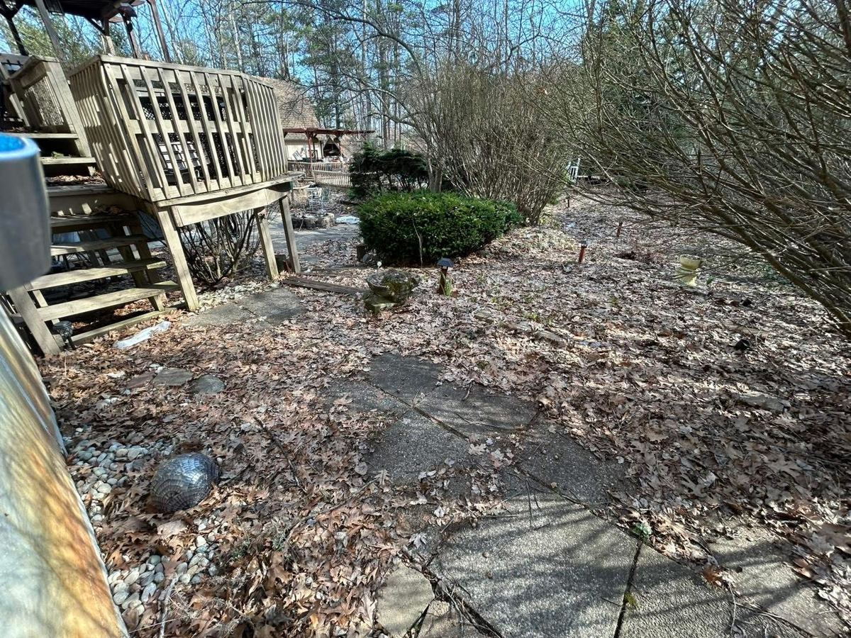 Before — paver patio covered in debris and a material pile