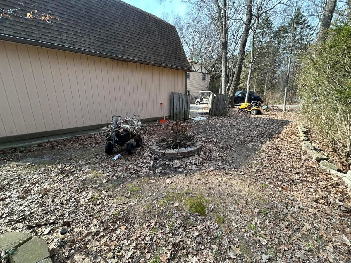 Before — backyard fire-pit area with leaves and debris